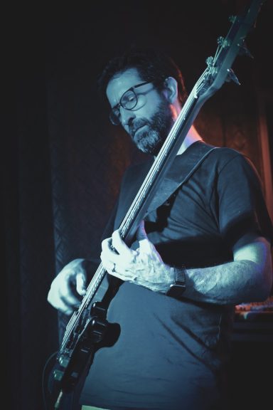 Bassist bei einem Live-Konzert im Sir Capulus in Füssen, spielt E-Bass auf der Bühne, Konzertstimmung in der Bar im Allgäu.