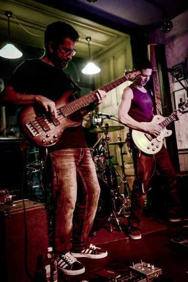 Live-Band im Sir Capulus in Füssen: Bassist und Gitarrist spielen auf der Bühne, Konzertstimmung in der Brunchbar im Allgäu. 
